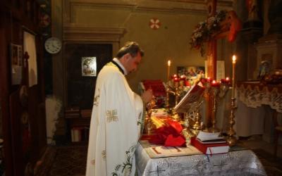 Părintele Marius Șutic în interiorul altarului în timpul unei liturghii.